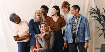 Diverse group of 6 women engineers posing for a photo in front of a beige backdrop