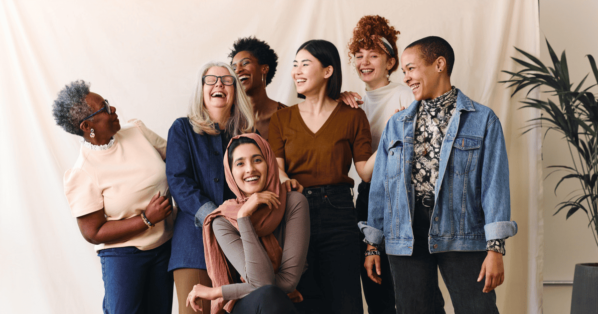 Diverse group of 6 women engineers posing for a photo in front of a beige backdrop