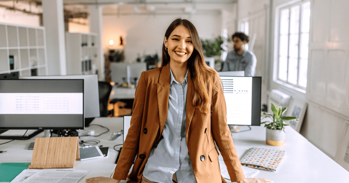 female product manager with a brown jacket in a modern looking office